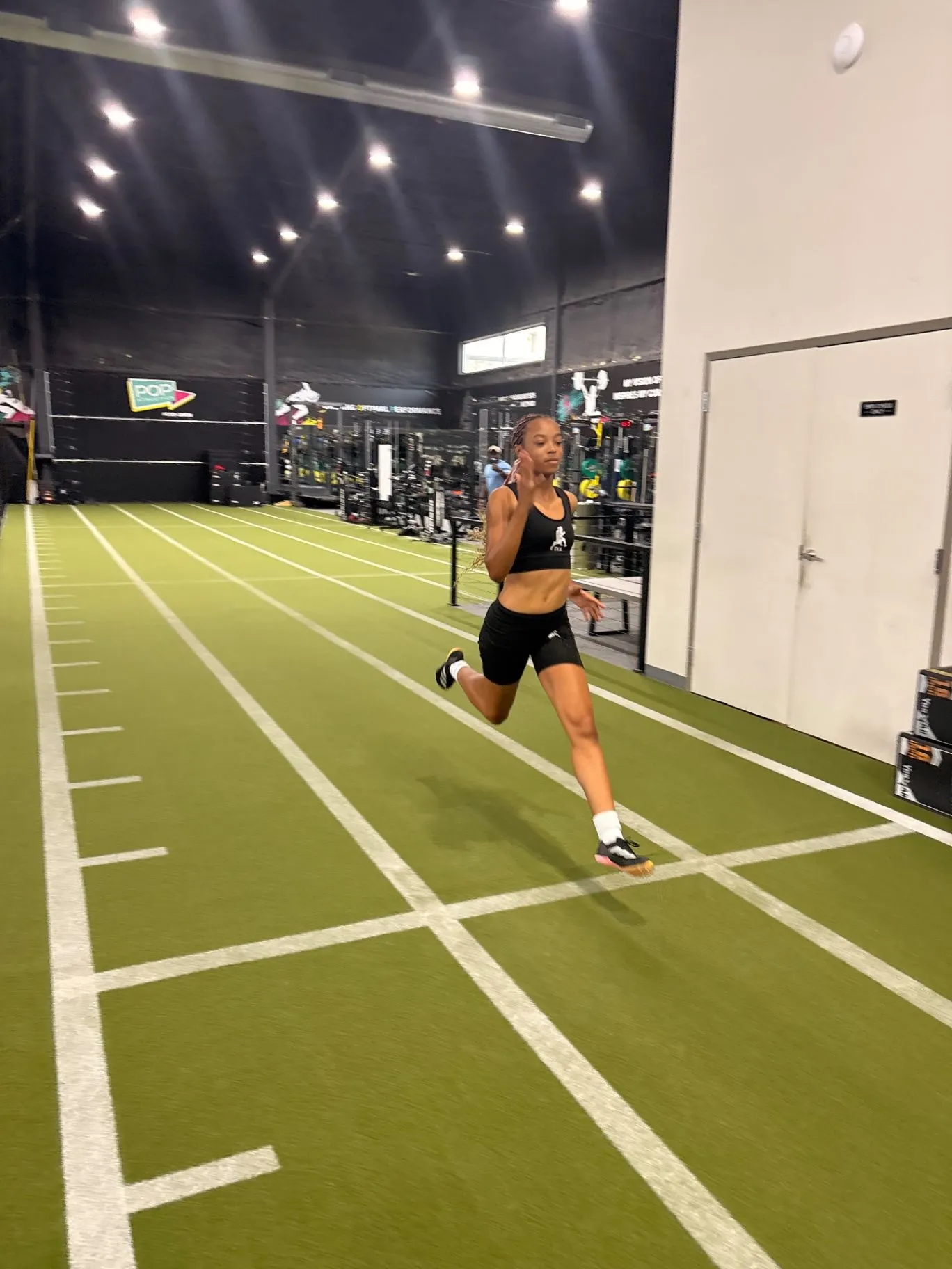 Nailah Belcher running during an indoor track training session