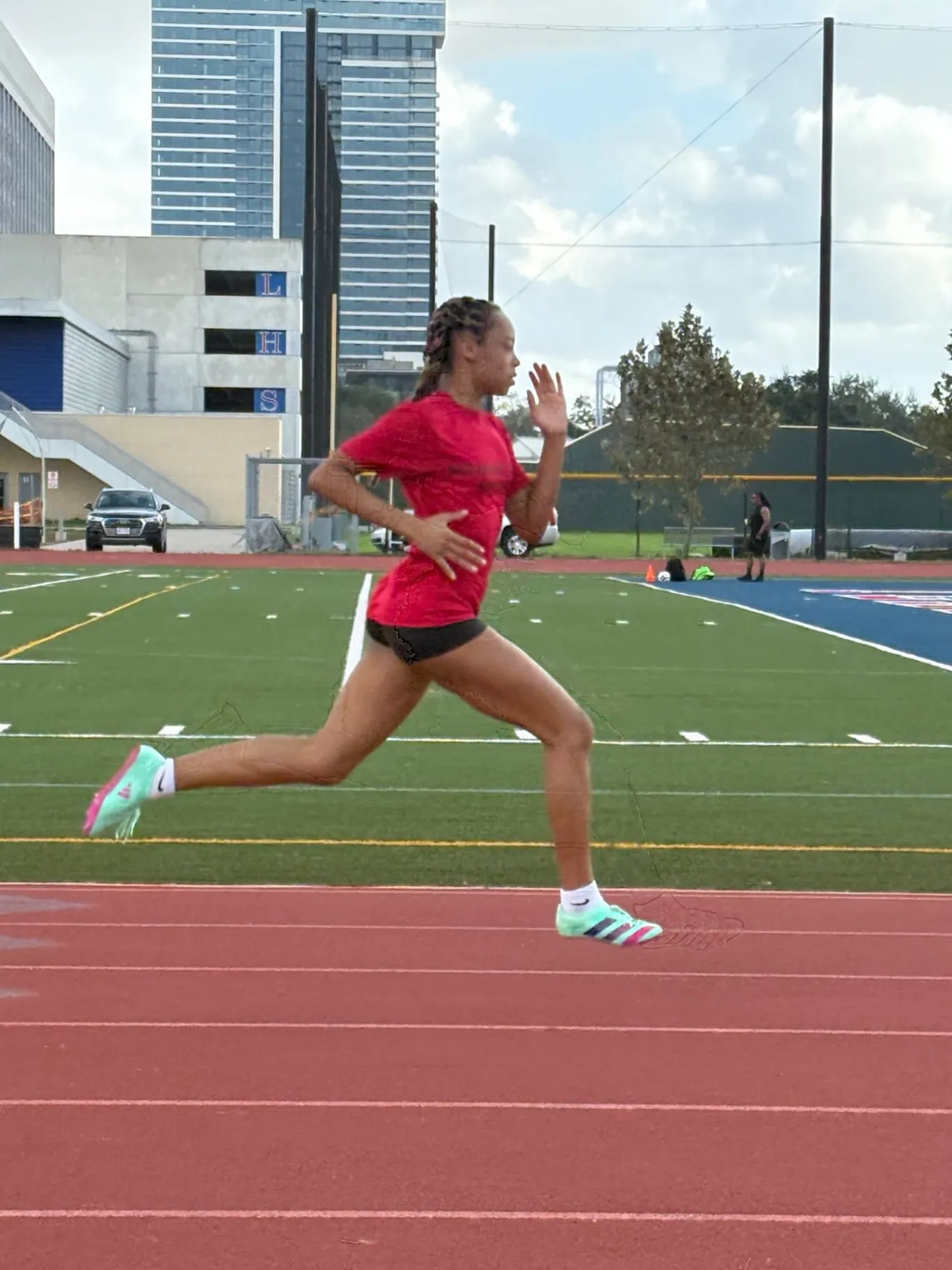 Nailah Belcher sprinting in a red shirt on an outdoor track